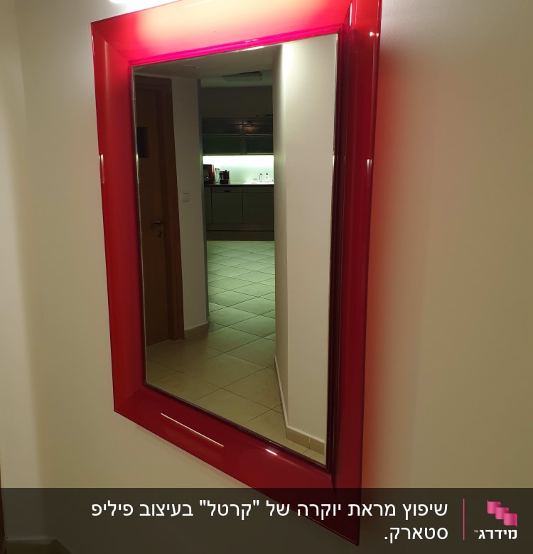 מראה עם מסגרת אדומה תלויה על קיר